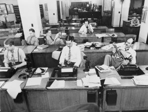 a buncha white NYT reporters in the news room in the 1930's