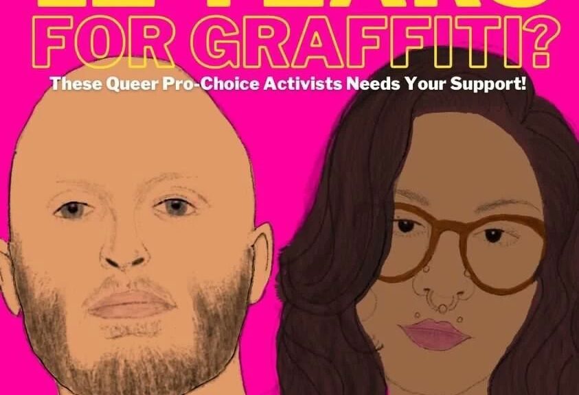 "12 YEARS FOR GRAFFITI? These Queer Pro-Choice Activists Needs Your Support! Donate to their legal defense at https://bit.ly/freeourfighters" Pictured are cartoons of a tan masculine-appearing person with shaved head and short beard alongside a brown skinned feminine-appearing person with glasses, a face piercings, long hair and lipstick